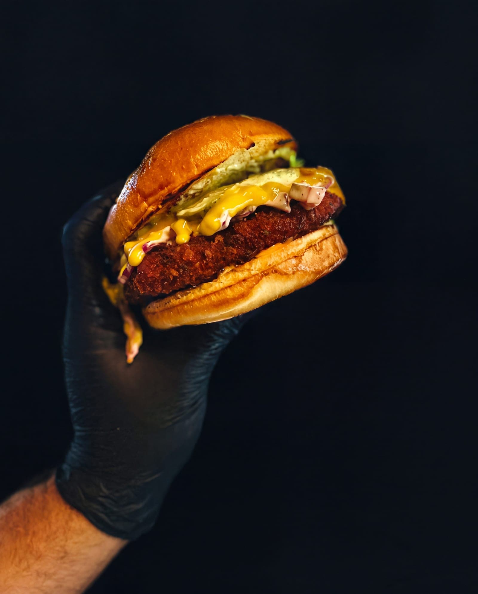 Crispy Chicken Burger mit Cheddar und Coleslaw, in der Hand gehalten